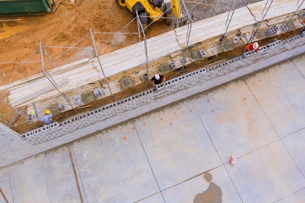 Concrete crew placing and leveling reinforced concrete slab during installation in Frisco, TX