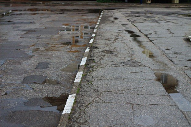 Uneven concrete slab with visible settlement caused by soil movement in North Texas