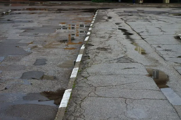 Uneven concrete slab with visible settlement caused by soil movement in North Texas