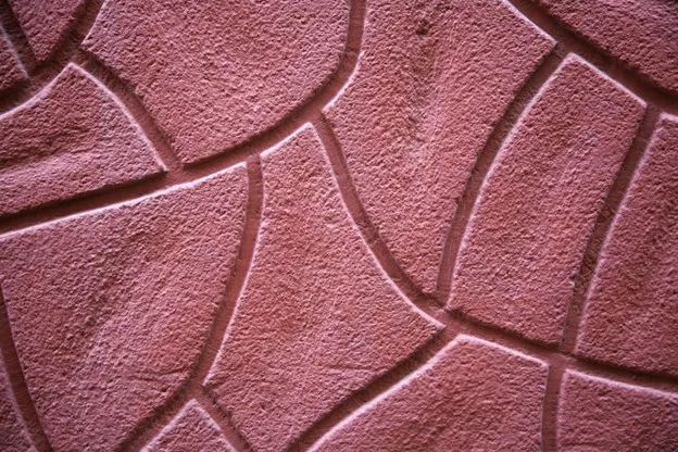 Decorative stamped concrete surface being finished with textured pattern during installation